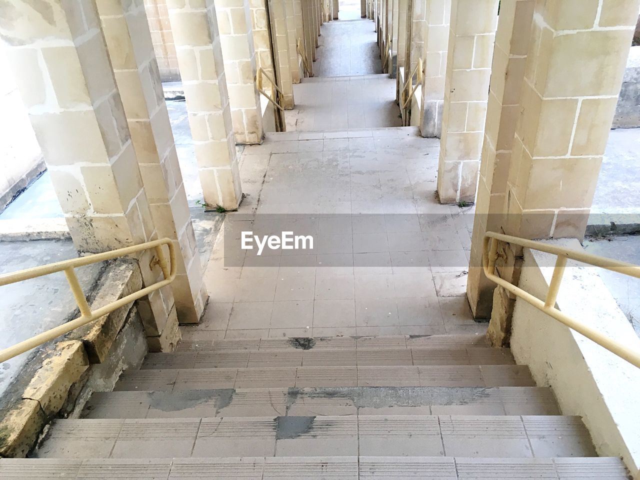 HIGH ANGLE VIEW OF STAIRS ALONG NARROW CORRIDOR