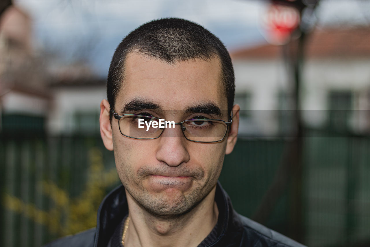 PORTRAIT OF YOUNG MAN WITH EYEGLASSES