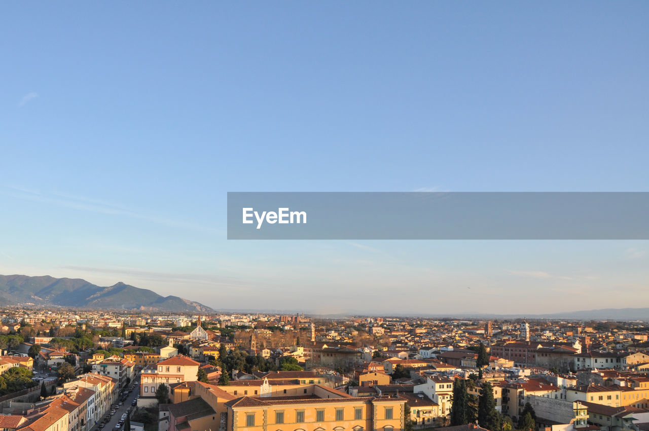 HIGH ANGLE VIEW OF TOWNSCAPE AGAINST BLUE SKY