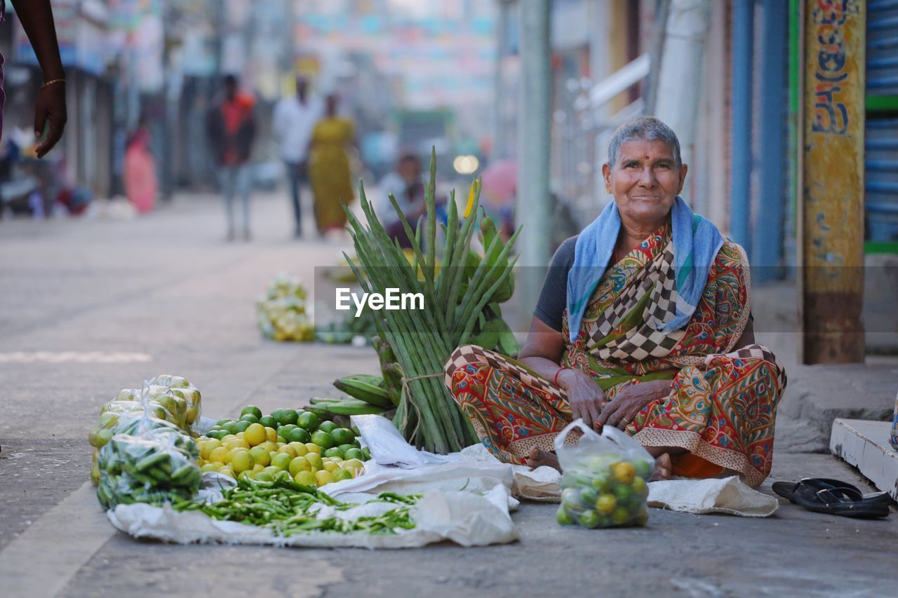 Portrait of woman sitting at market stall