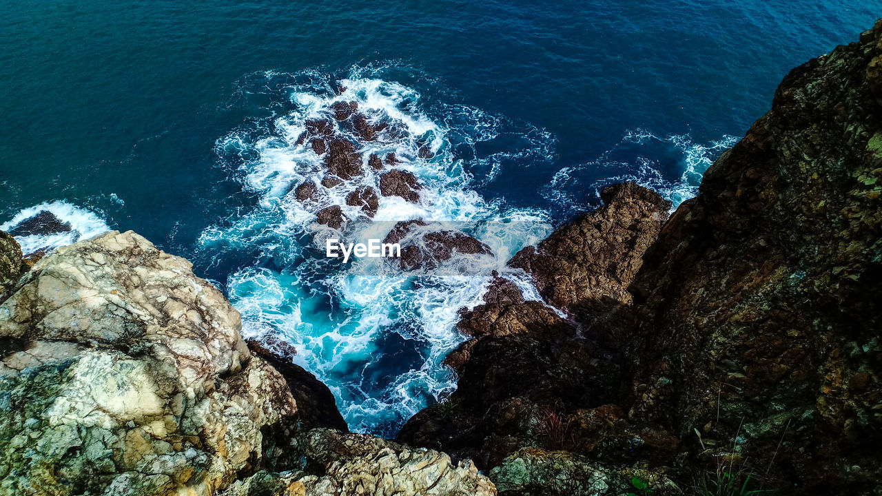 High angle view of rocks by sea