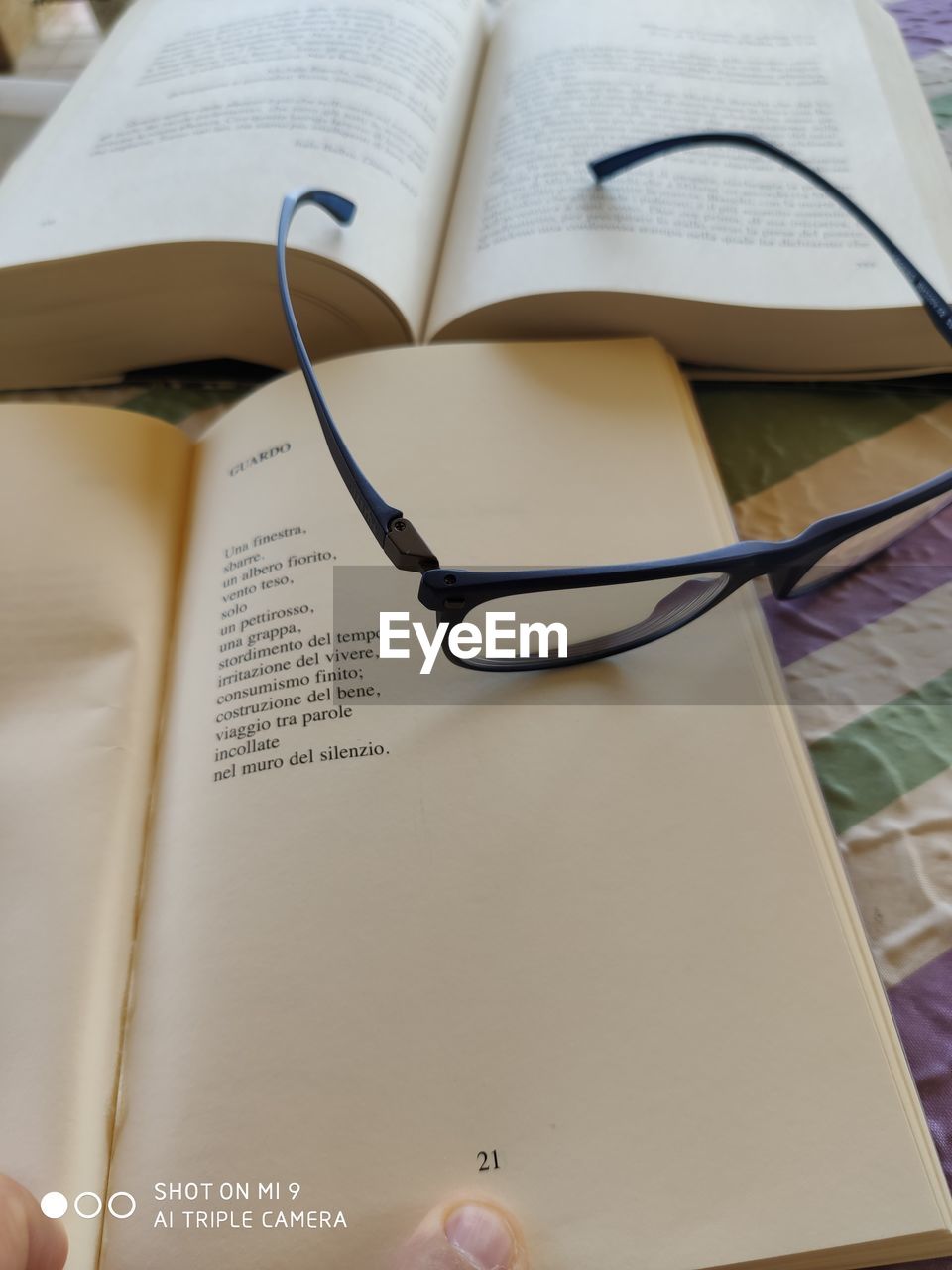 HIGH ANGLE VIEW OF EYEGLASSES ON BOOKS