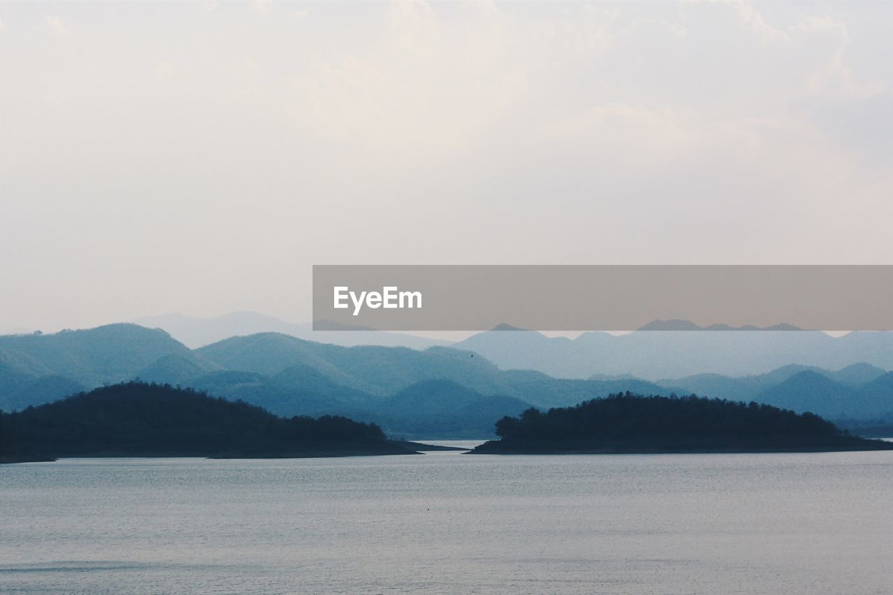 SCENIC VIEW OF LAKE BY MOUNTAIN AGAINST SKY