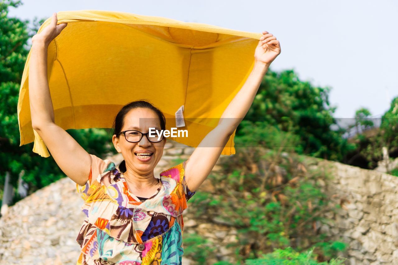 Smiling woman looking away while holding fabric 