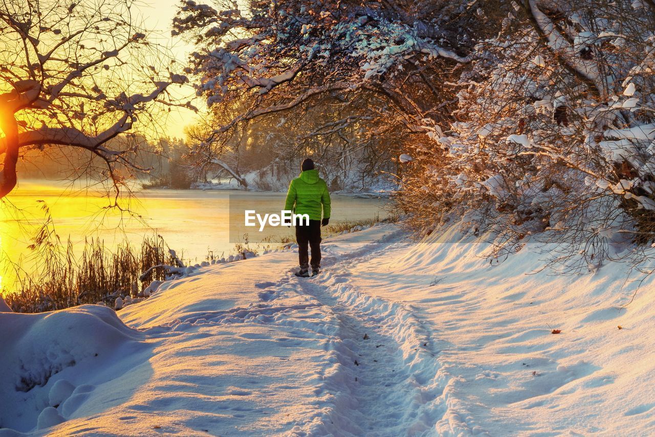 rear view of woman walking on snow