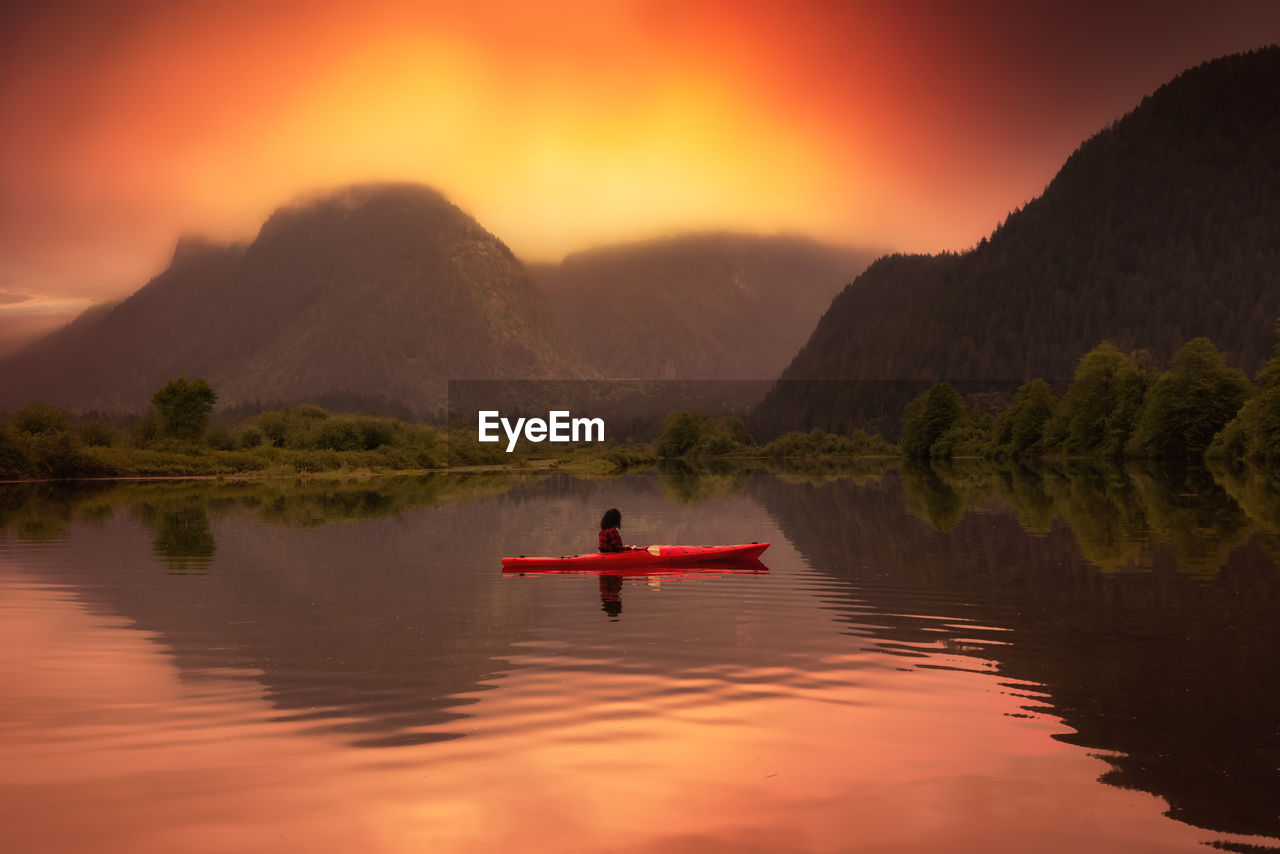 BOAT ON LAKE AGAINST SKY DURING SUNSET