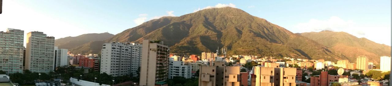 PANORAMIC SHOT OF CITYSCAPE AGAINST MOUNTAINS