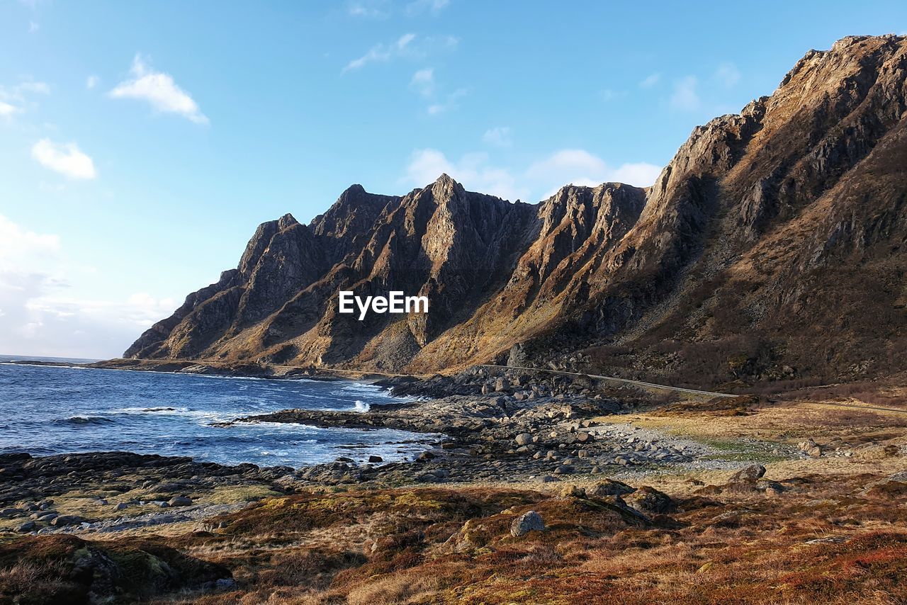 Scenic view of sea and mountains against sky