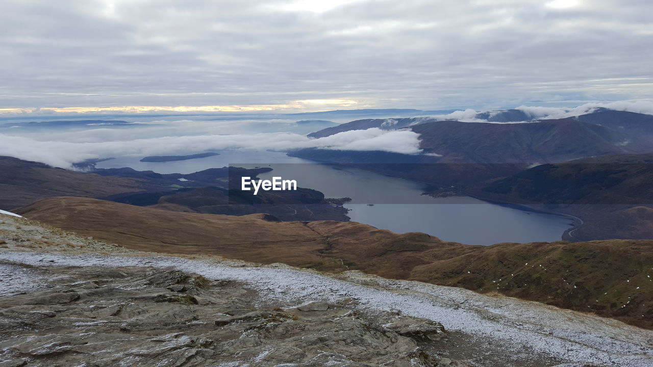 Scenic view of sea and mountains against sky