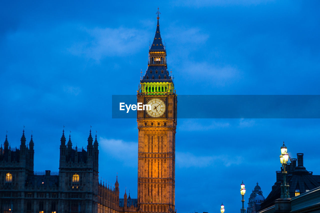 Low angle view of illuminated big ben against sky at dusk
