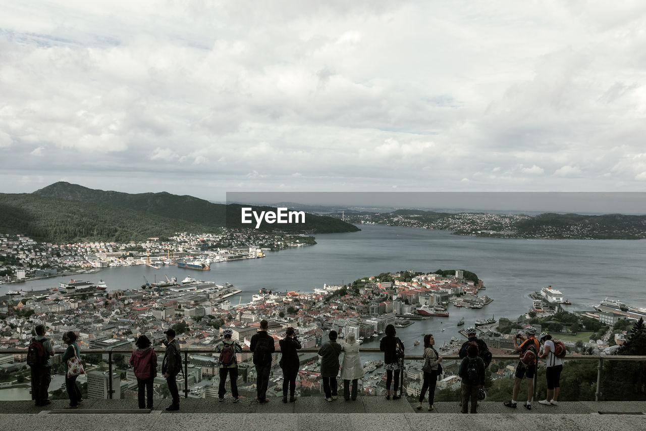 People looking at sea against sky