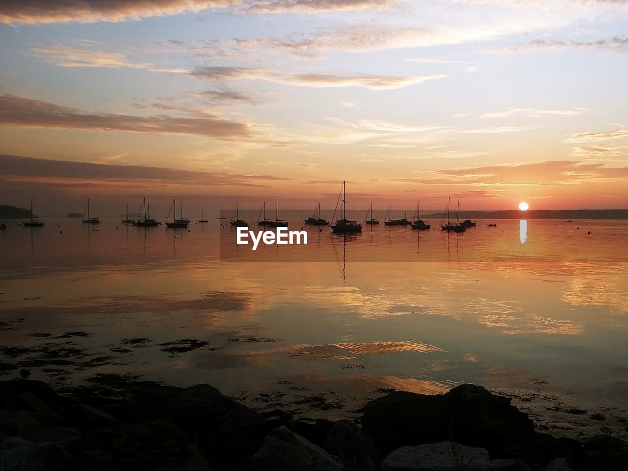 Scenic view of sea and sail boats . morning sunrise at east end beach in portland, maine.