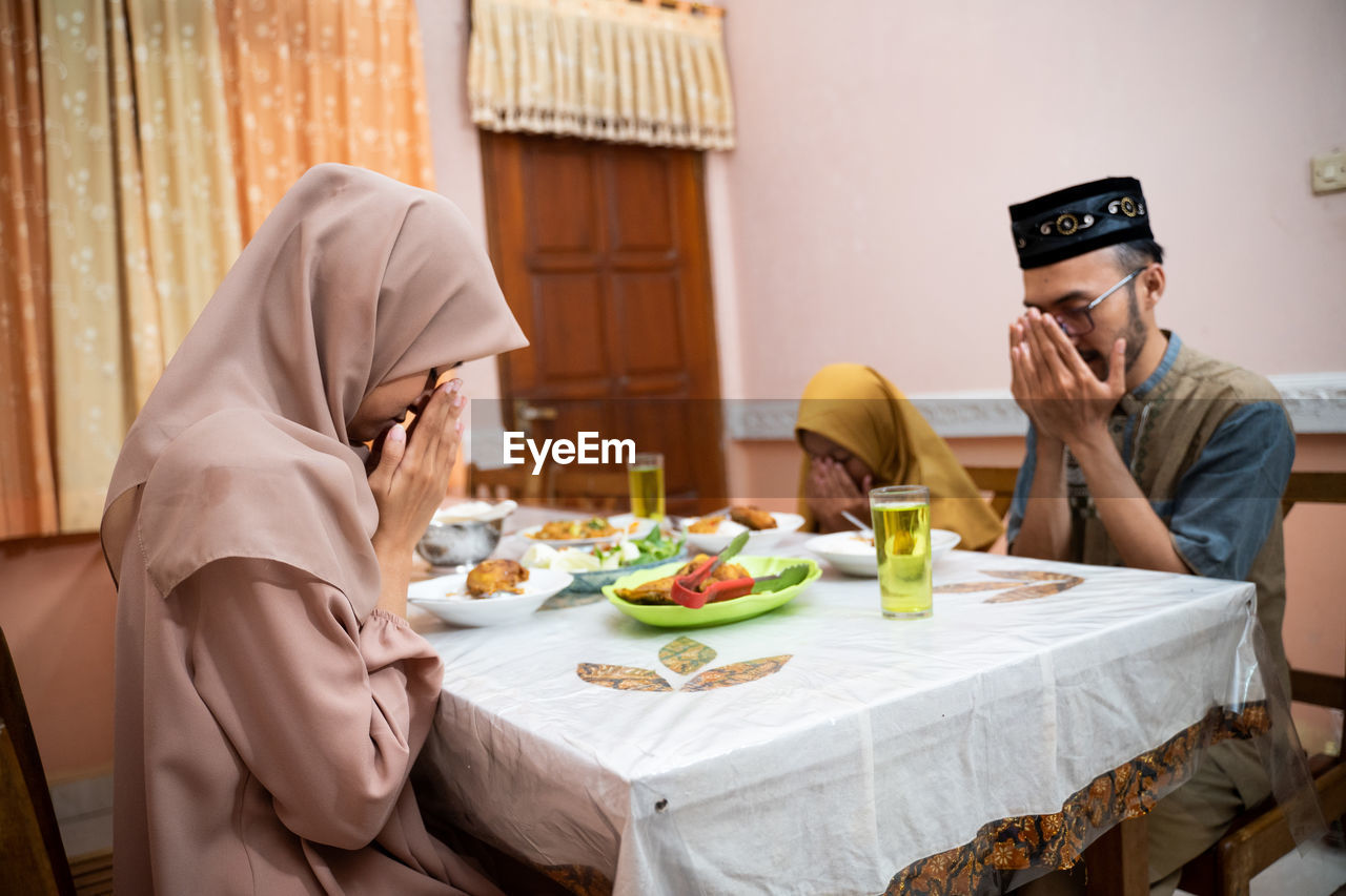 Happy family praying before eating