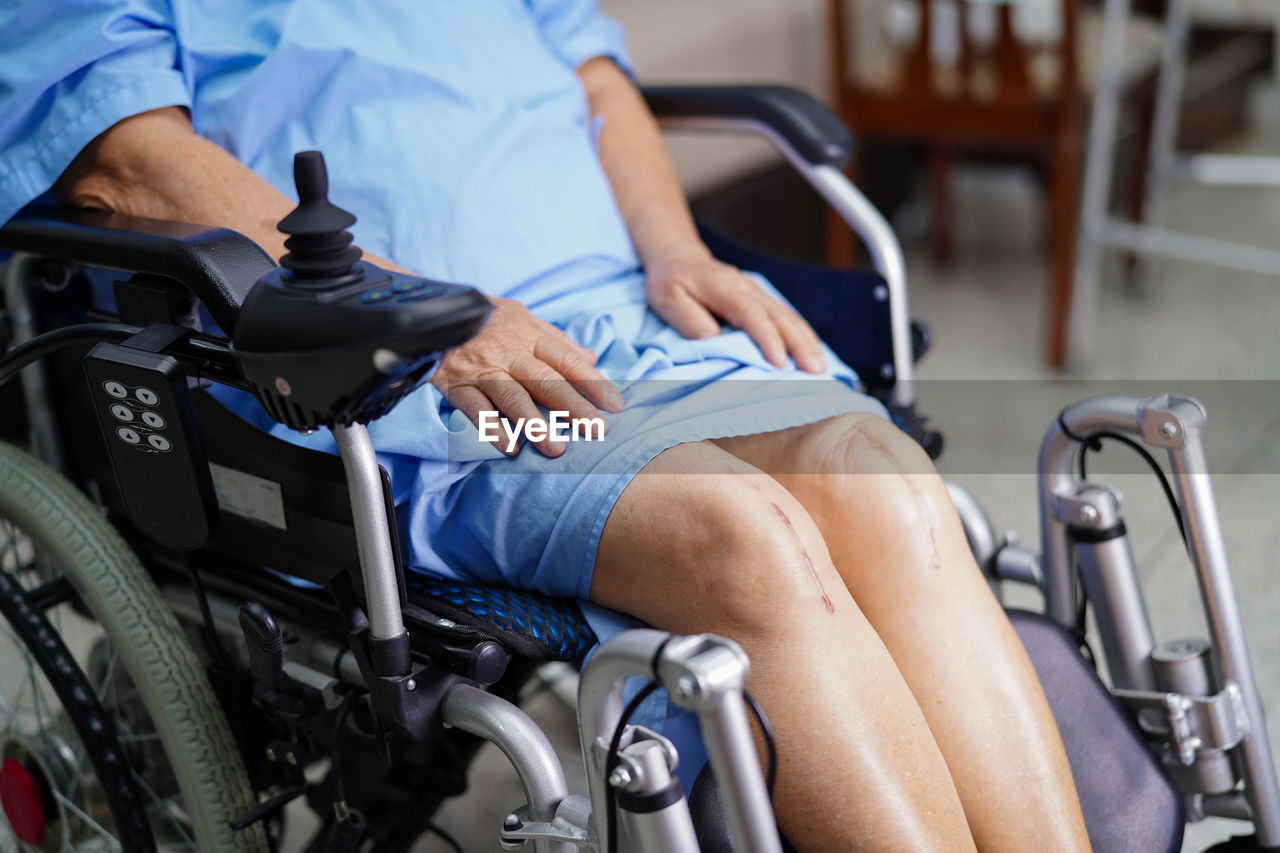 Midsection of disabled woman sitting on wheelchair