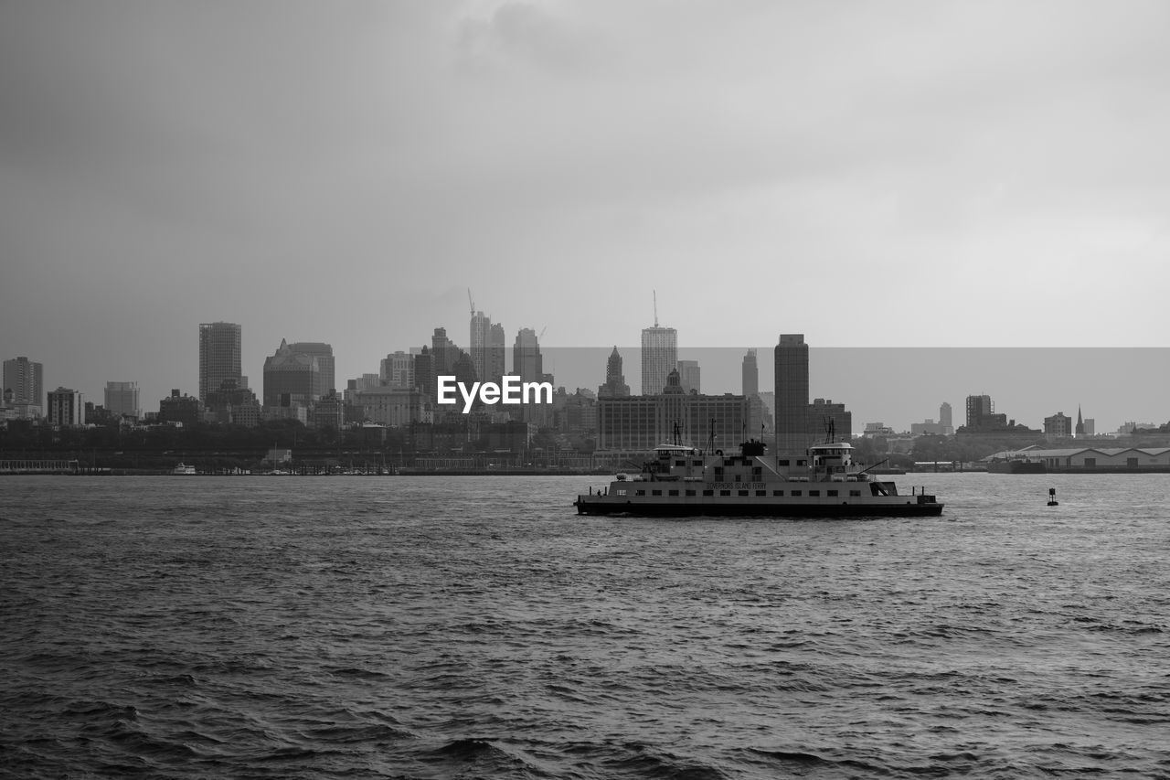 SEA BY BUILDINGS AGAINST SKY