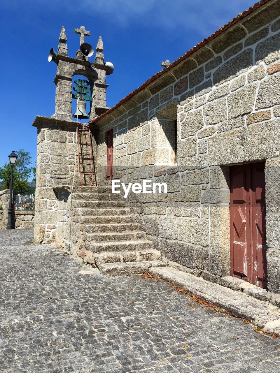 Steps by bell tower at old church against sky