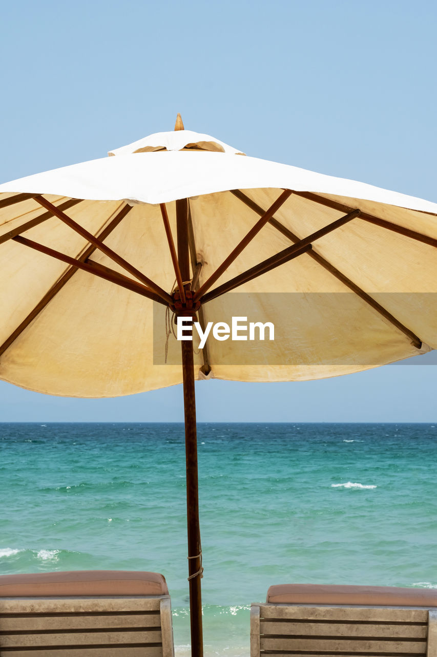 Two beach chairs and umbrella against seascape. inspirational summertime rest.