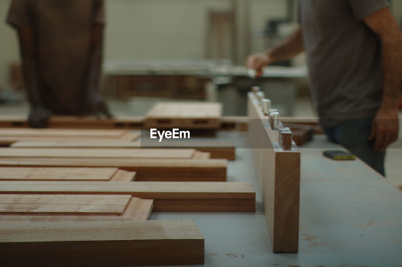 Midsection of male carpenters working in workshop
