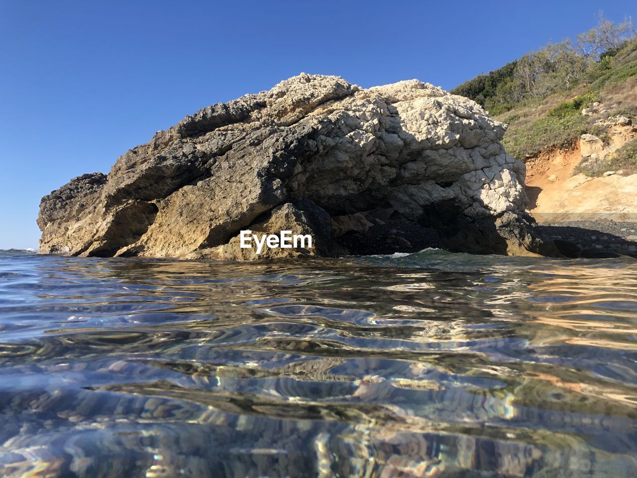 ROCK FORMATION IN SEA AGAINST CLEAR SKY