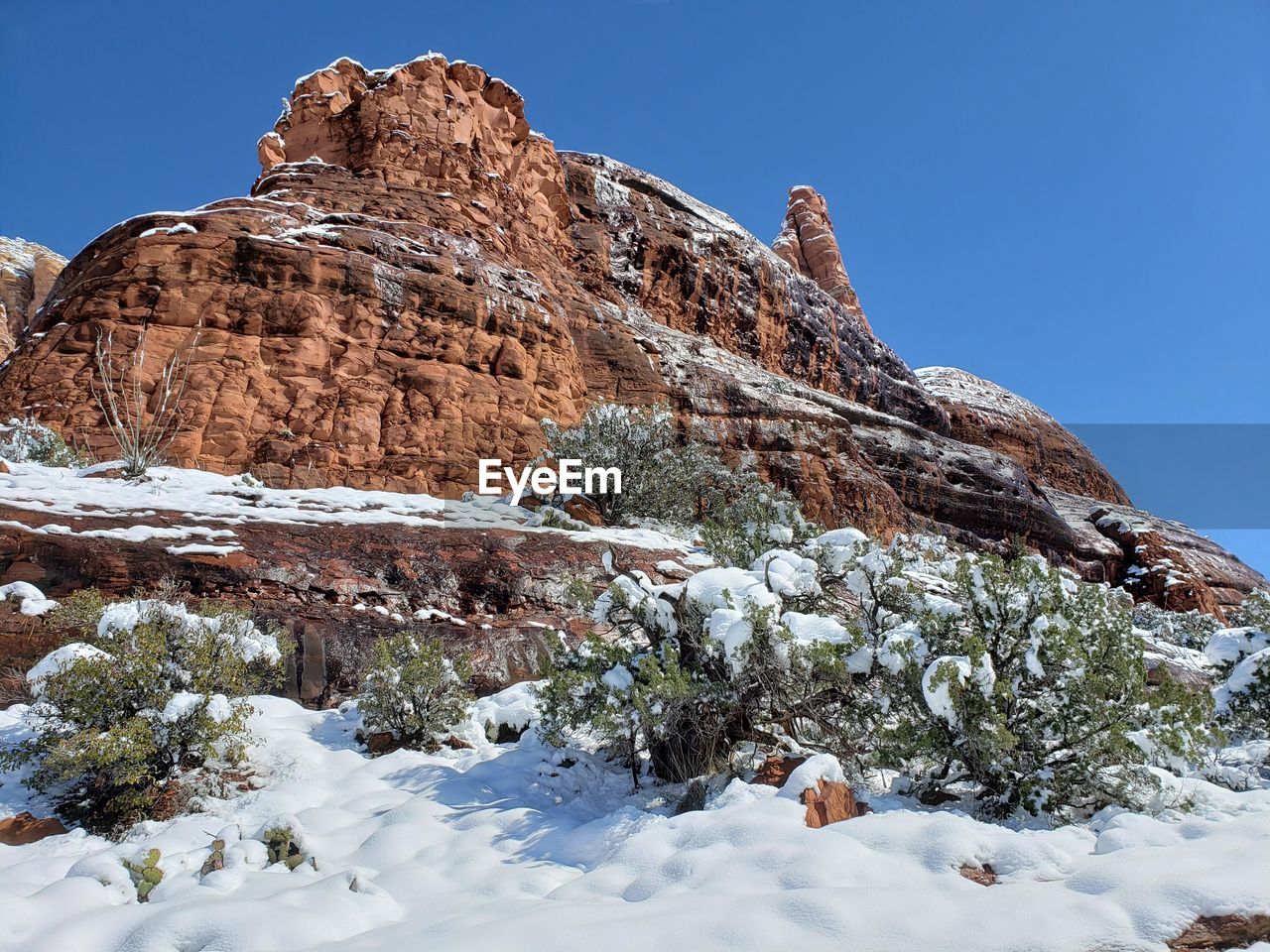 Low angle view of rock formation against sky during winter