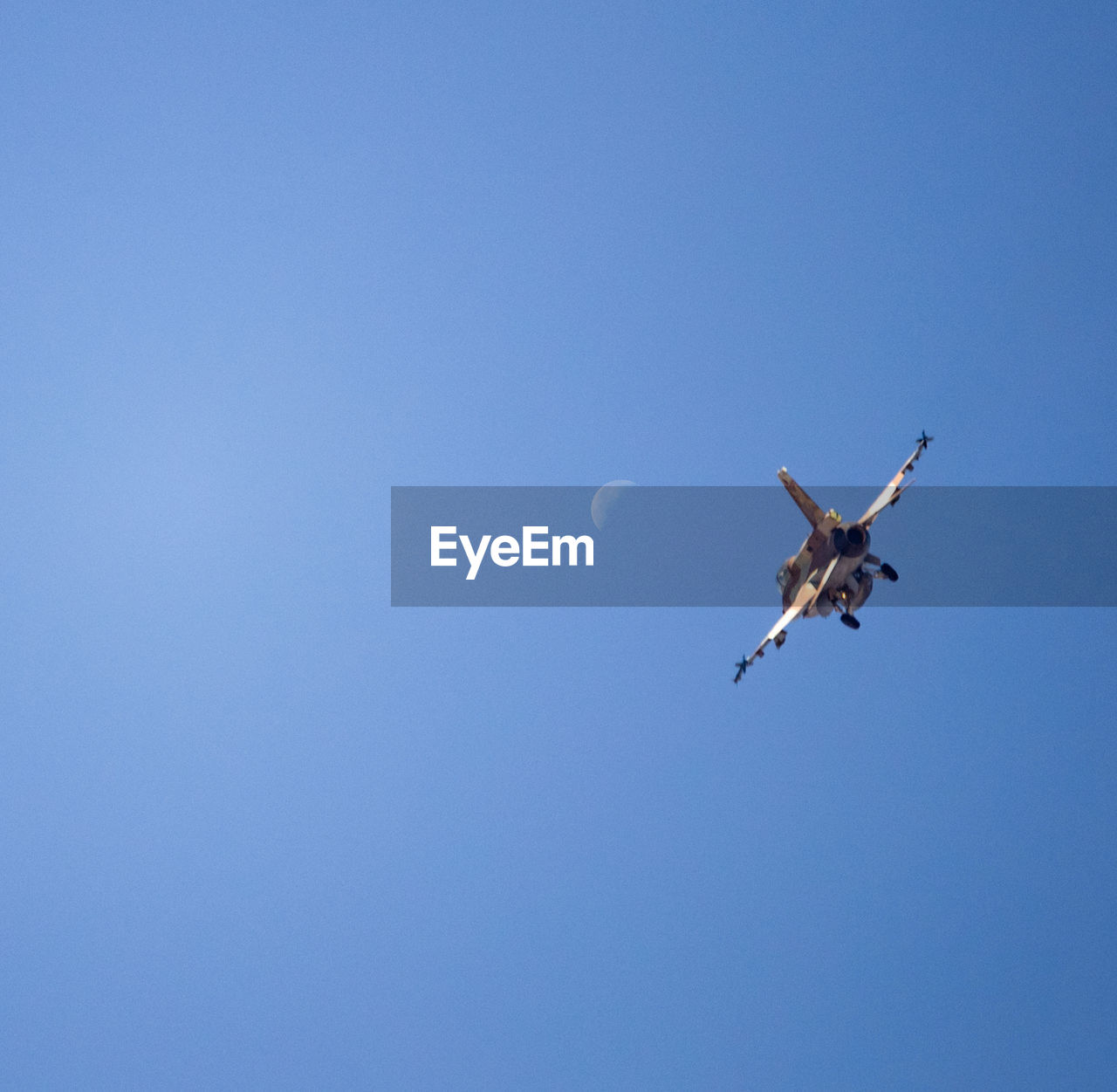 Low angle view of airplane flying against clear blue sky