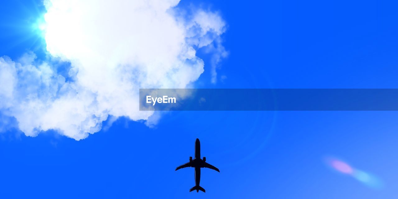 LOW ANGLE VIEW OF AIRPLANE FLYING AGAINST BLUE SKY