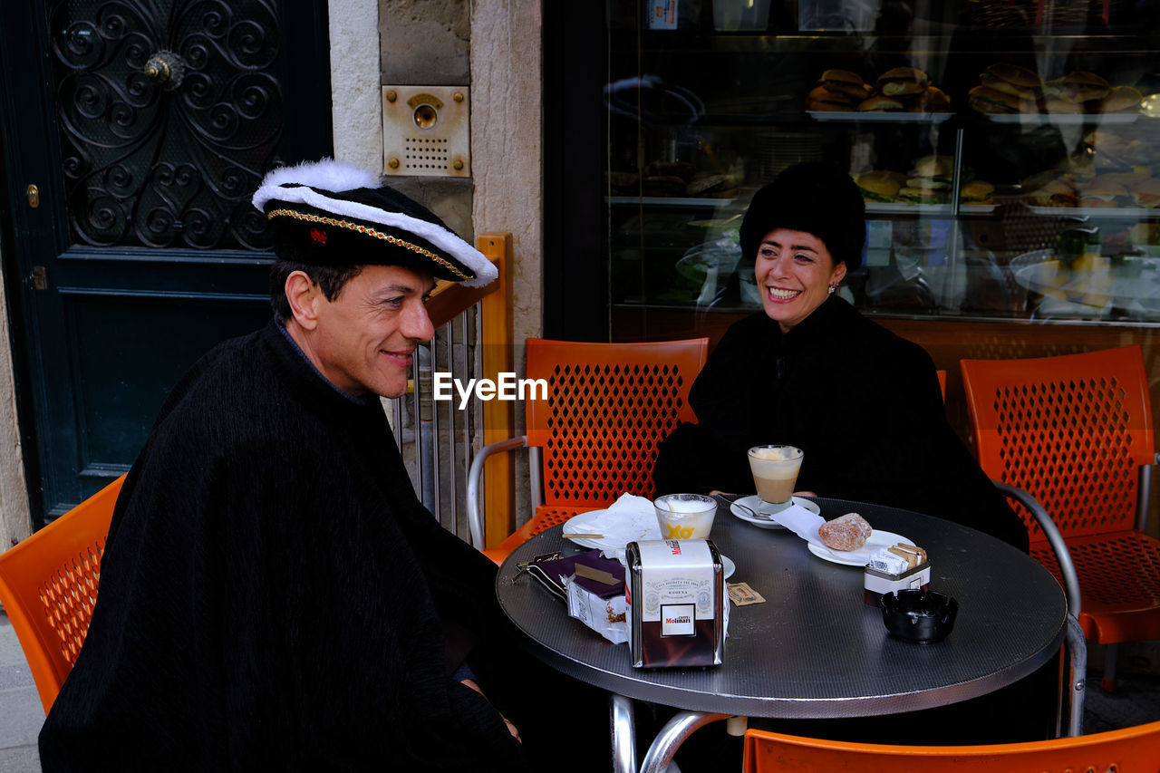 PORTRAIT OF WOMAN SITTING AT RESTAURANT