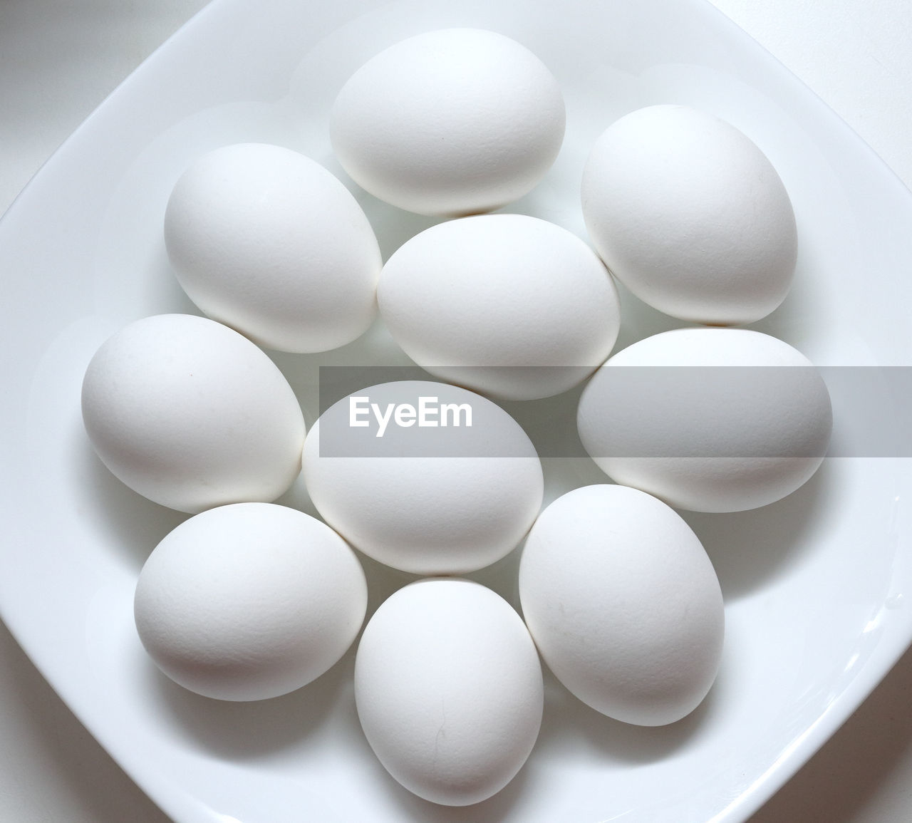 HIGH ANGLE VIEW OF EGGS IN WHITE CONTAINER