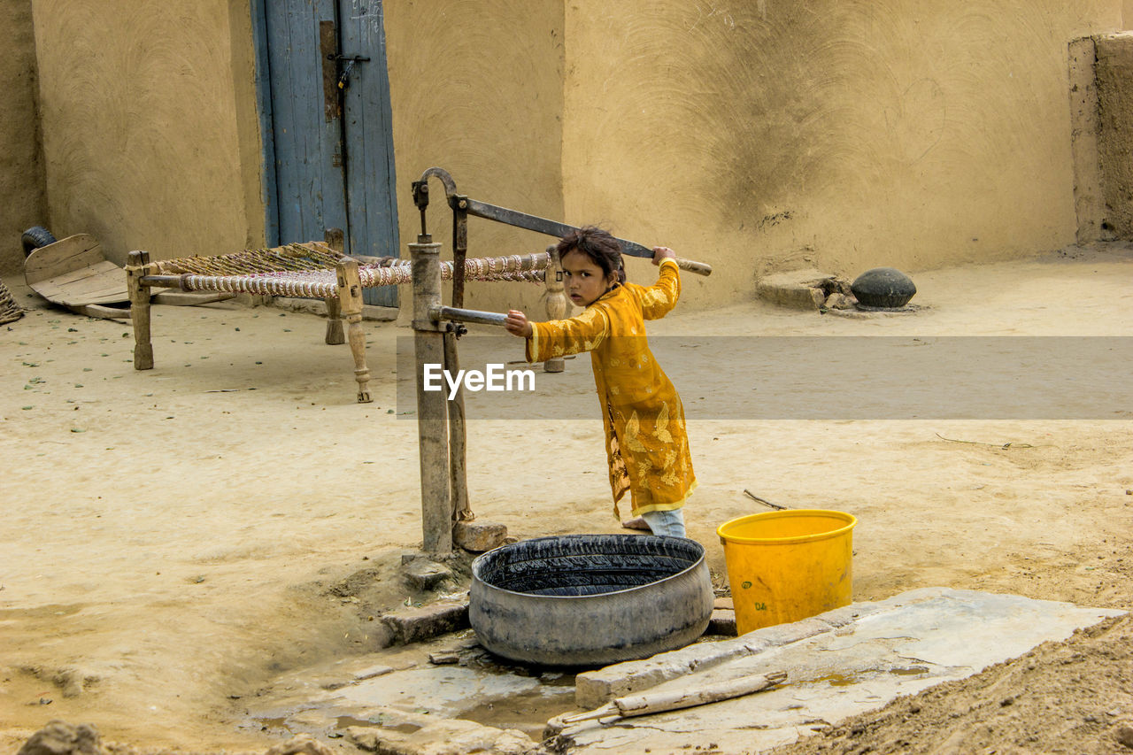 SIDE VIEW OF A BOY WORKING ON STONE STRUCTURE