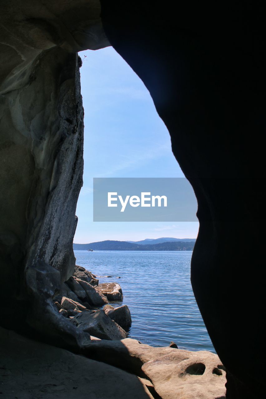 Rock formations by sea against sky