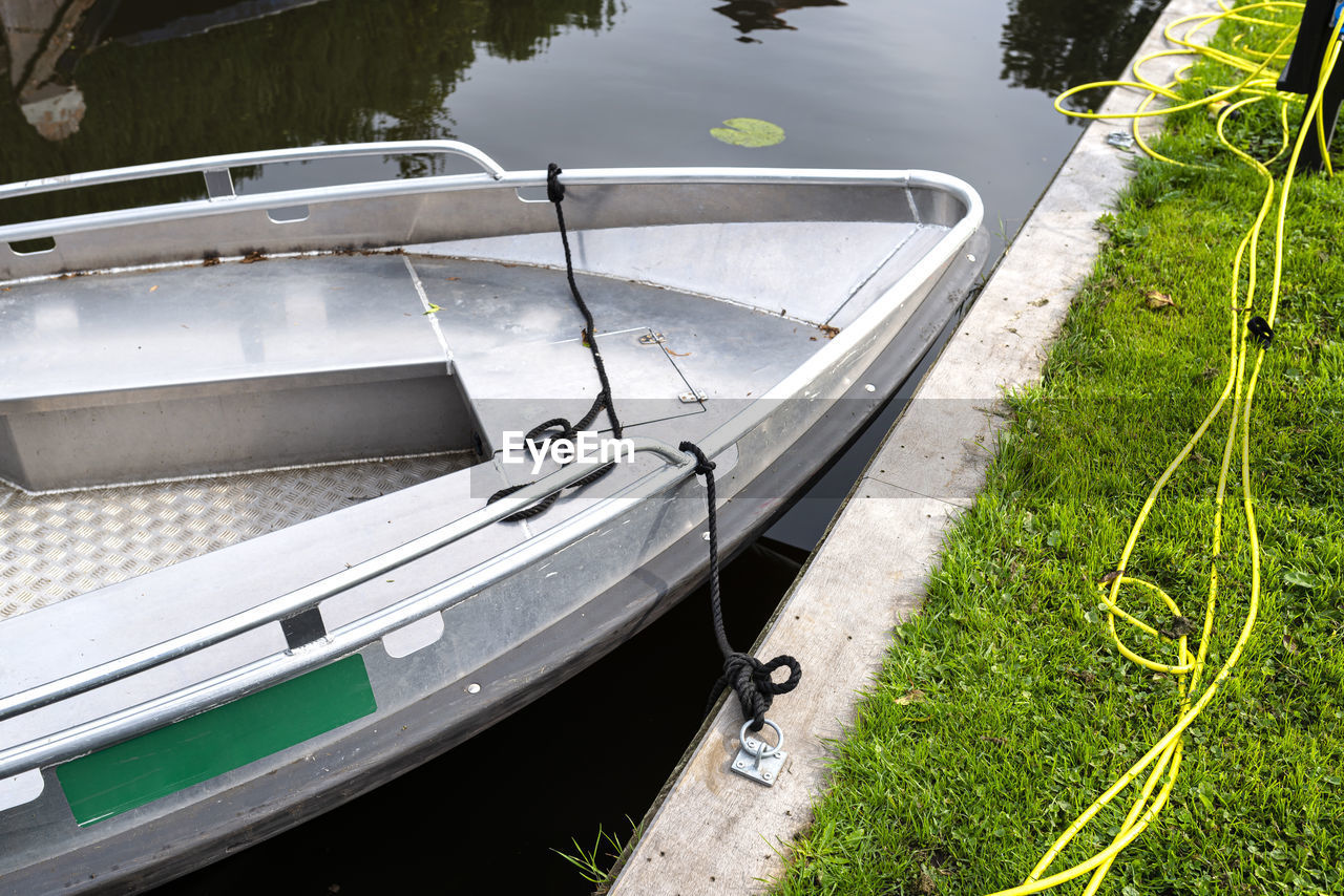 Metal boat moored in the channel is connected with a cable to a socket in order to charge batteries.