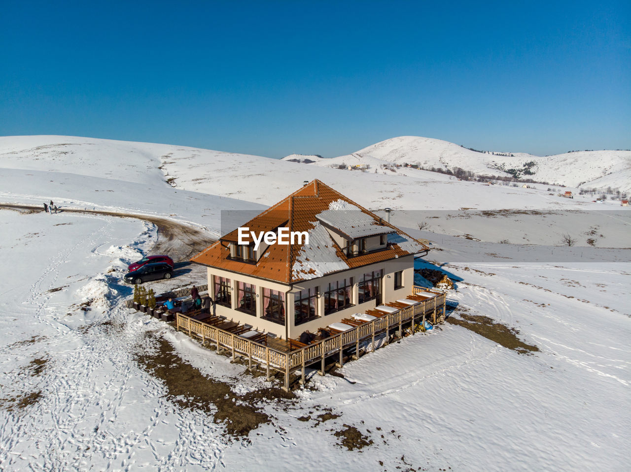 HOUSES ON SNOWCAPPED MOUNTAINS AGAINST CLEAR BLUE SKY