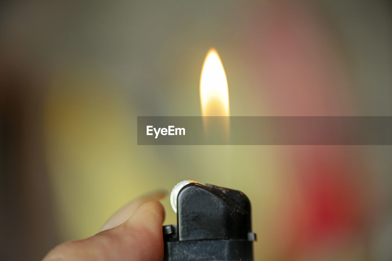 CLOSE-UP OF HAND HOLDING CANDLE