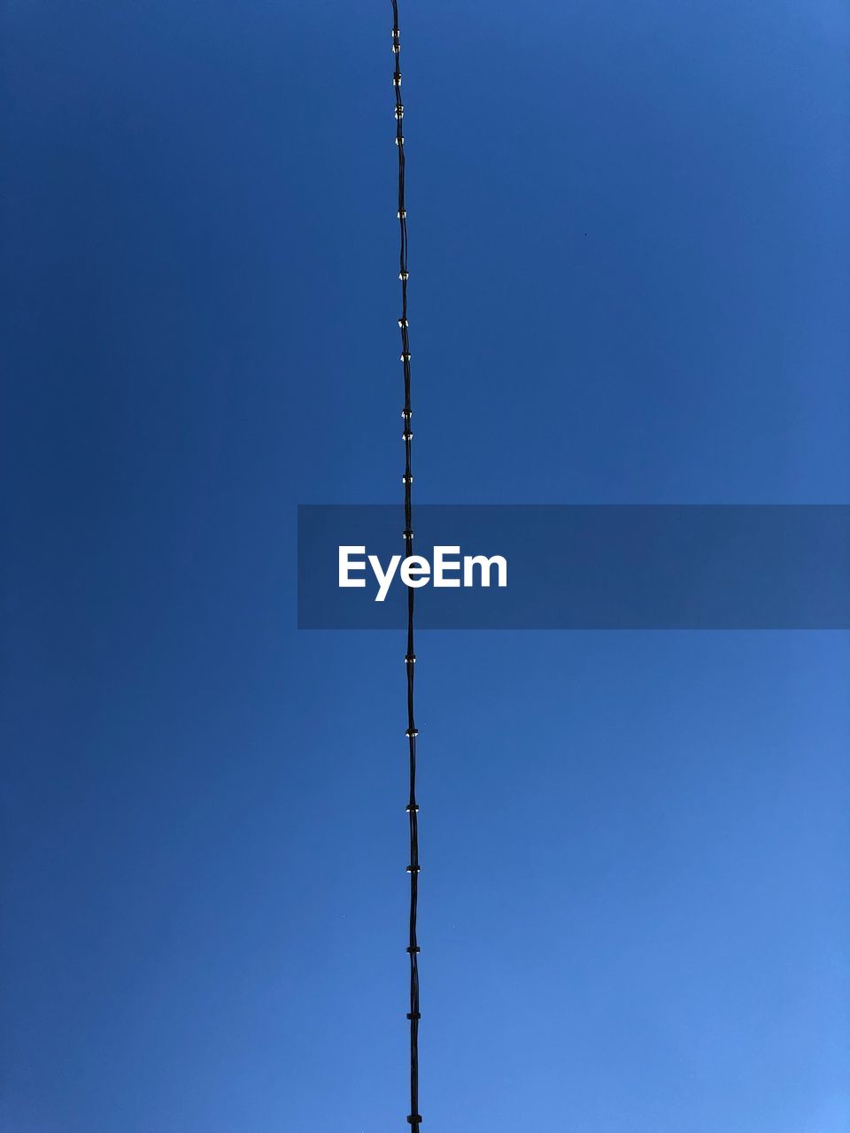 Low angle view of a cable against clear blue sky