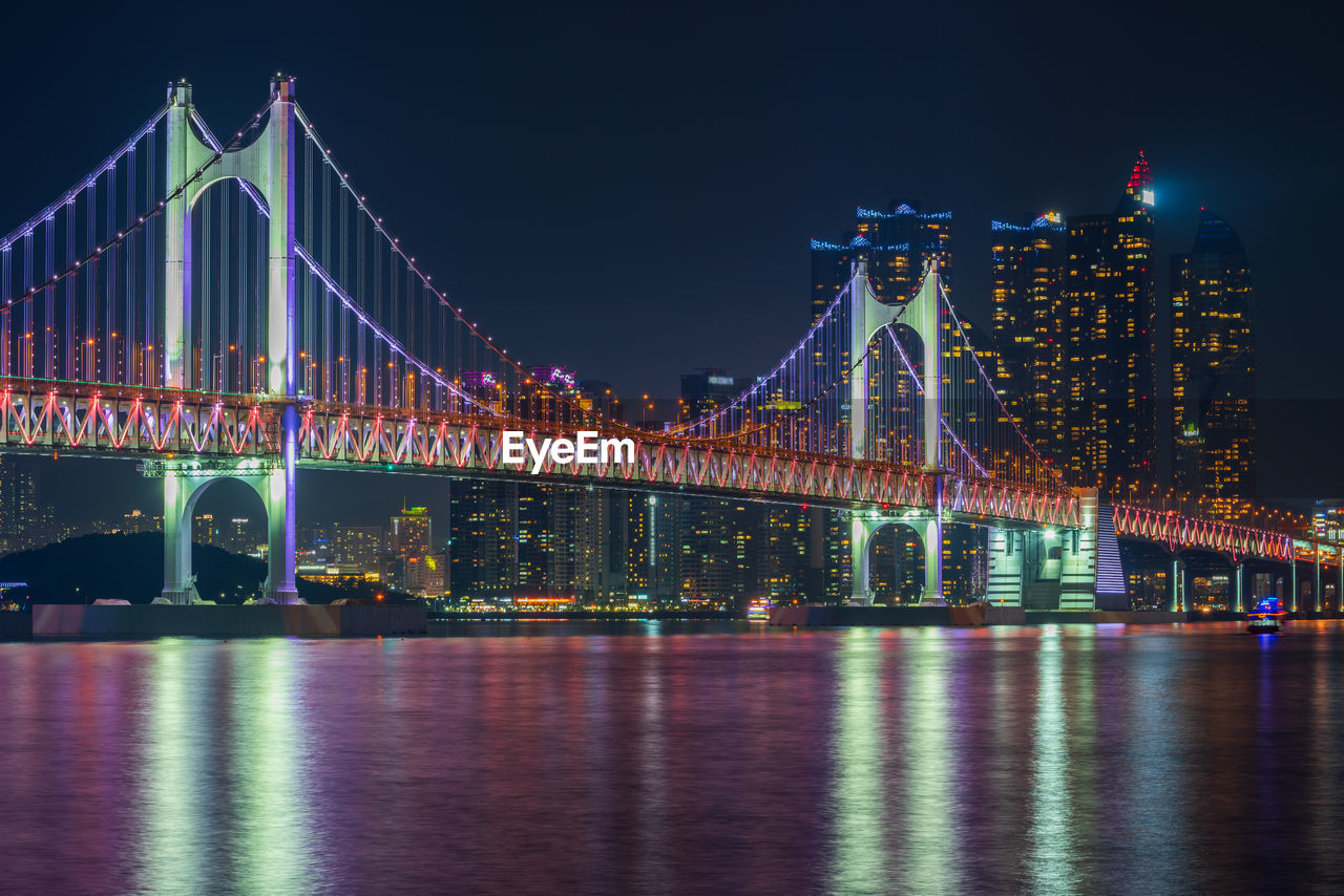 ILLUMINATED BRIDGE OVER RIVER