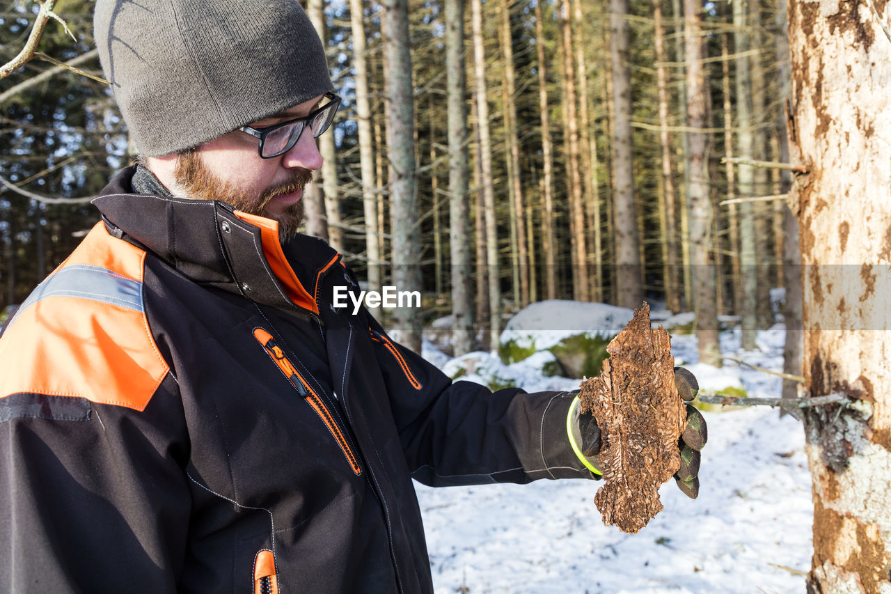 Man holding tree bark