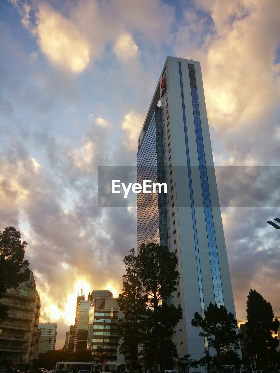 LOW ANGLE VIEW OF SKYSCRAPERS AGAINST CLOUDY SKY