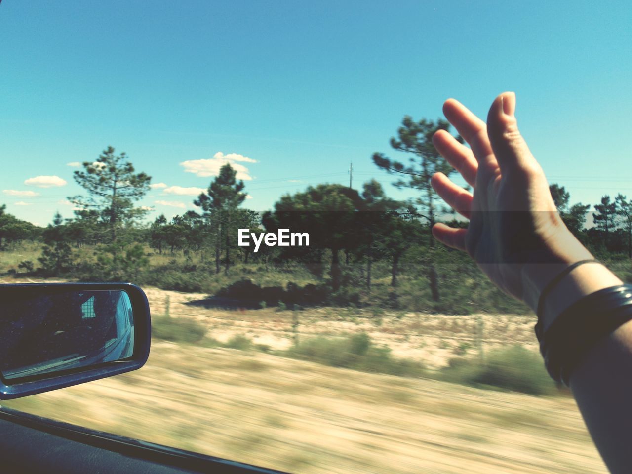 Cropped hand of man in moving car