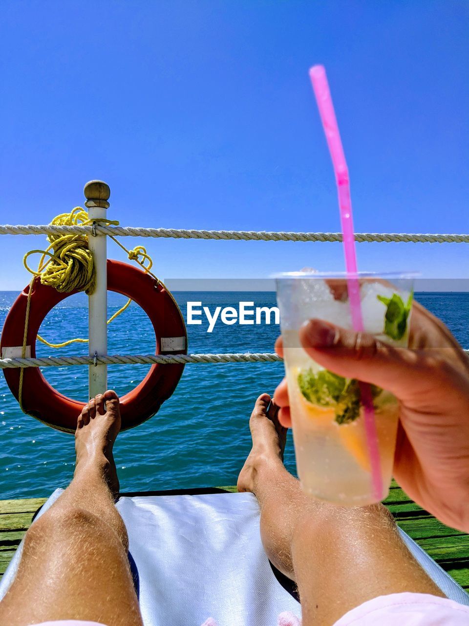 Midsection of man drinking glass against sea