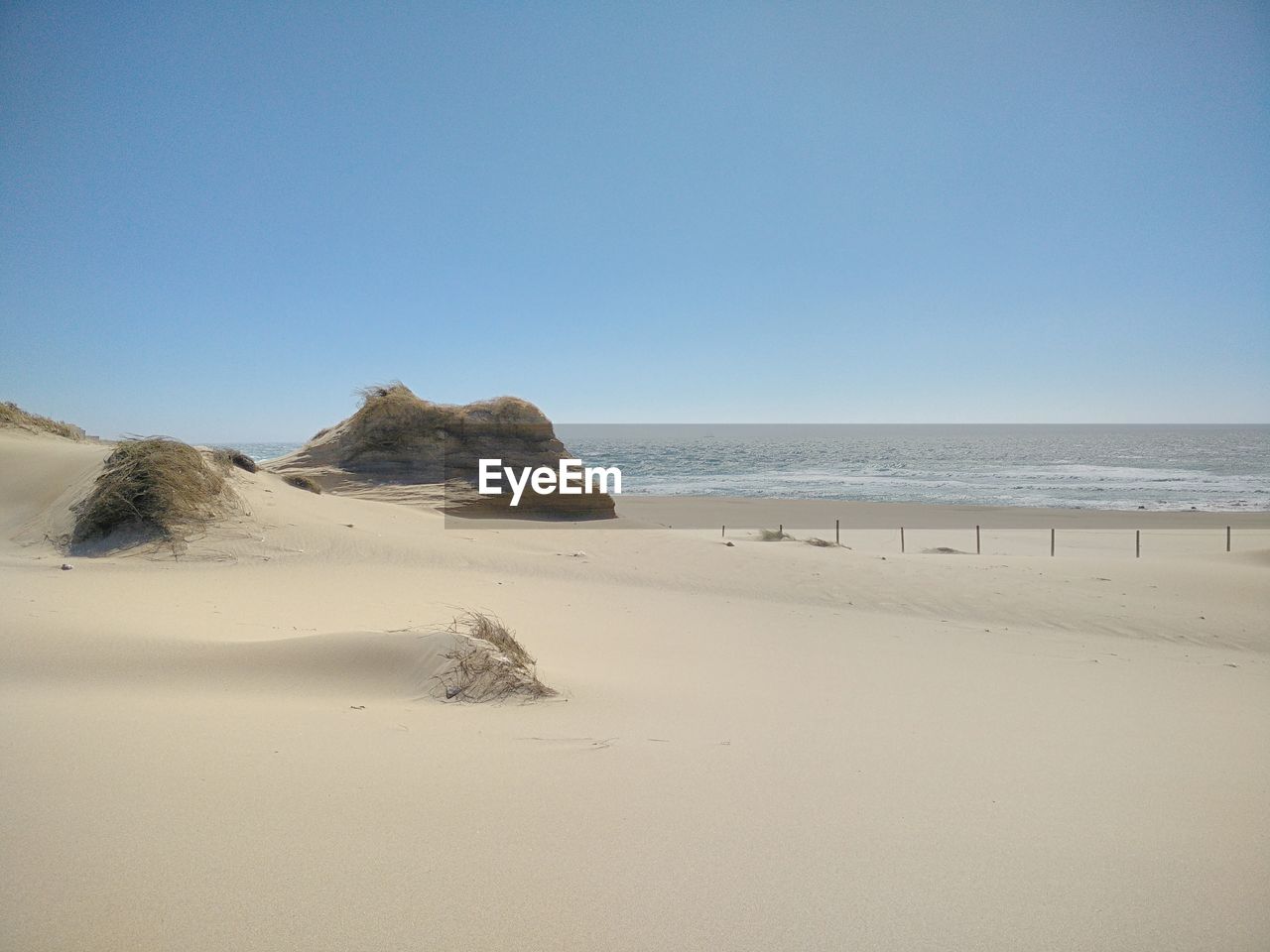 Scenic view of beach against clear sky