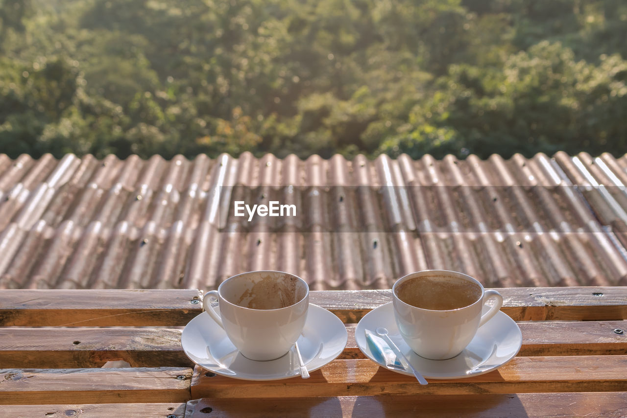 CLOSE-UP OF COFFEE CUP ON TABLE AGAINST WALL