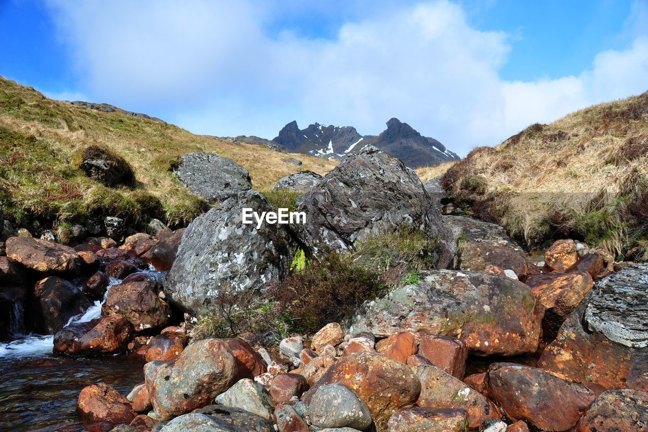 River stream amidst rocks against sky