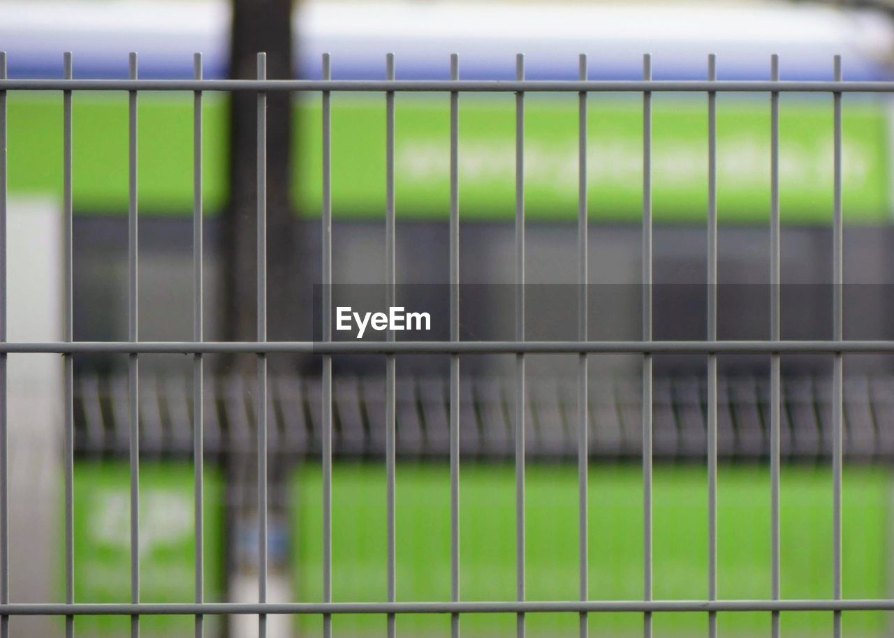 CLOSE-UP OF FENCE BY RAILING