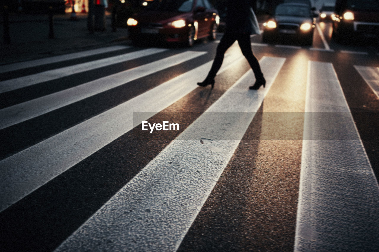 Low section of person crossing road