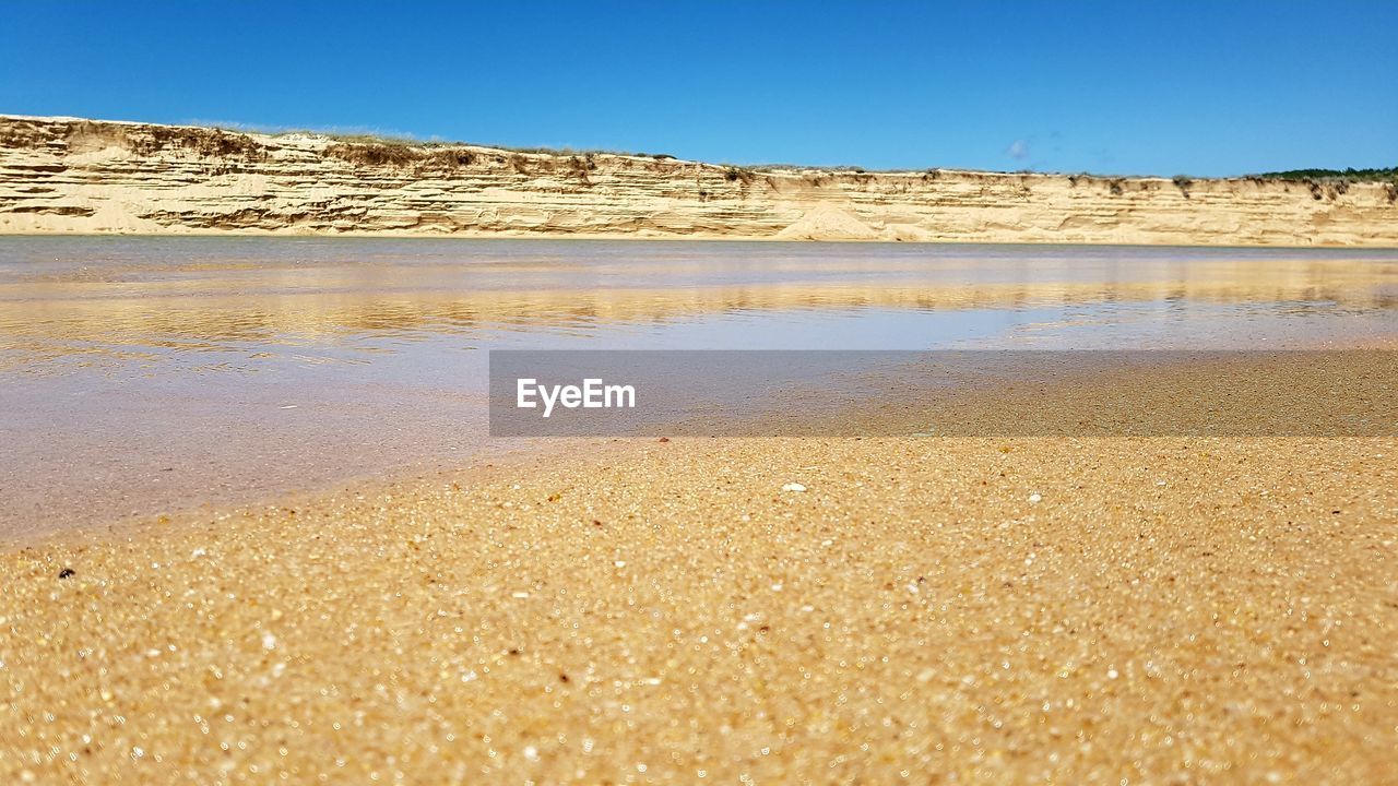 SCENIC VIEW OF SANDY BEACH AGAINST CLEAR BLUE SKY