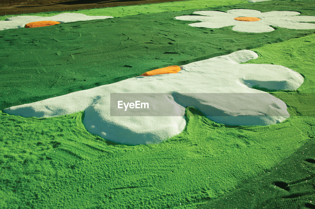 HIGH ANGLE VIEW OF STONES ON FIELD DURING SUNRISE