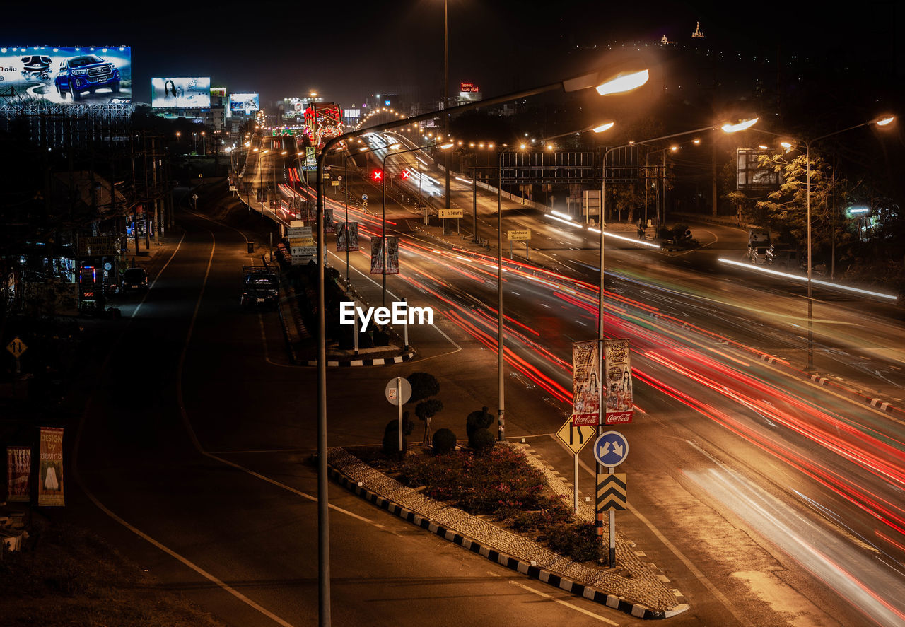 HIGH ANGLE VIEW OF LIGHT TRAILS ON RAILROAD TRACKS AT NIGHT