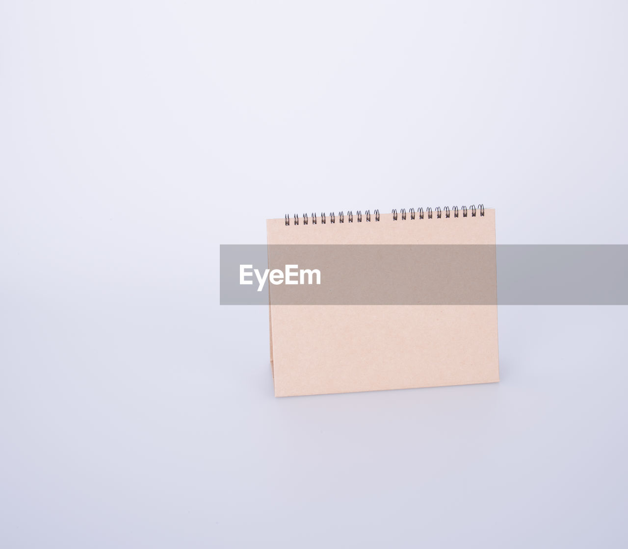 High angle view of blank brown desk calendar on white background
