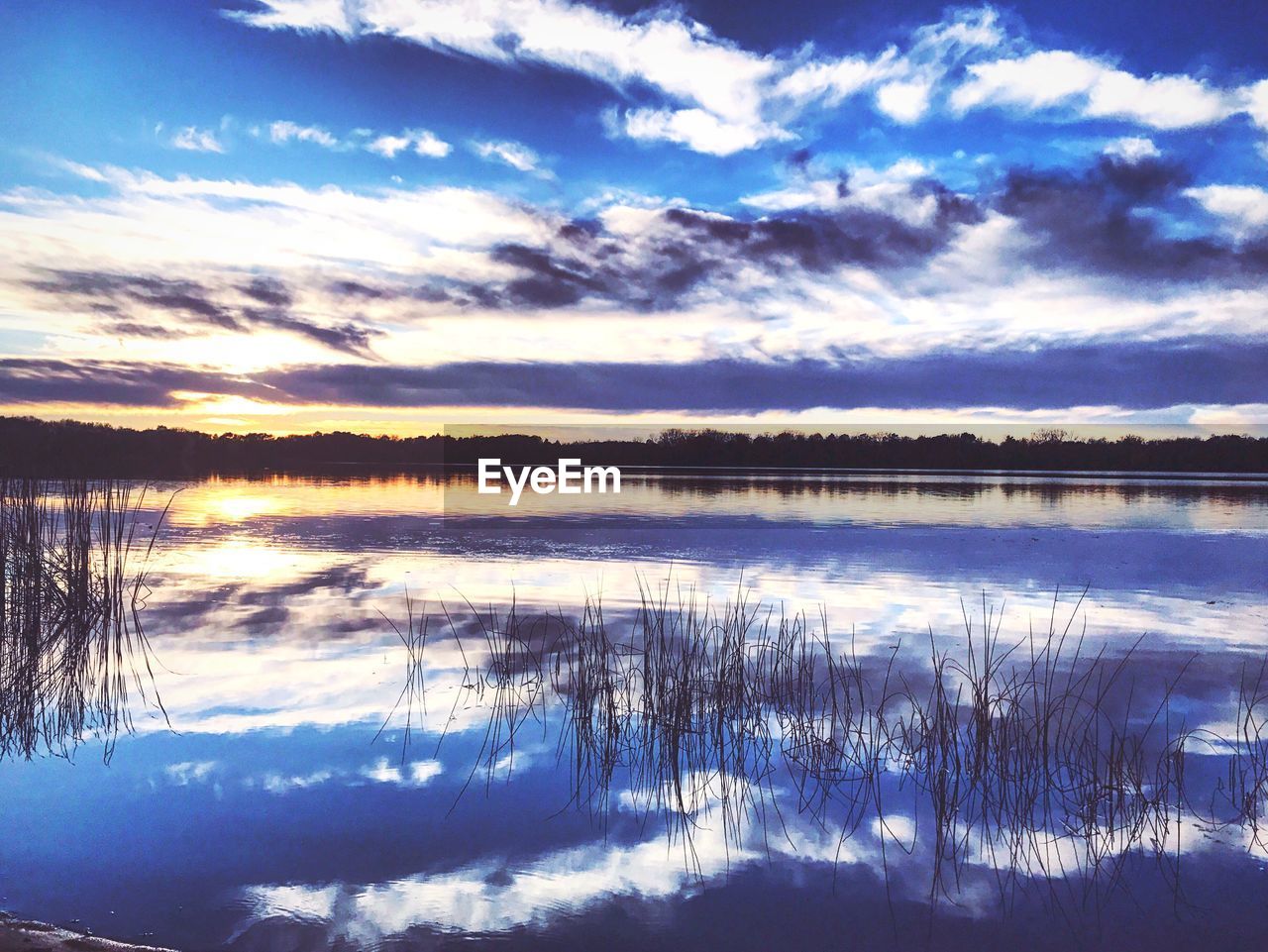 REFLECTION OF SKY ON LAKE DURING SUNSET