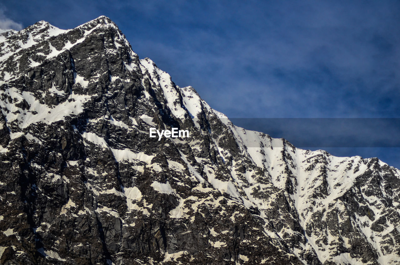 Low angle view of snowcapped mountain against sky